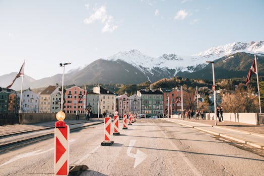 Charming street view of Innsbruck with colorful buildings and snow-capped mountains in the background.